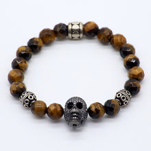 Cargar imagen en el visor de la galería, Pulsera de Ojo de Tigre con dije de Calavera y Circonia.