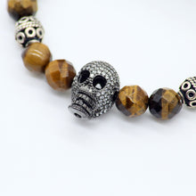 Cargar imagen en el visor de la galería, Pulsera de Ojo de Tigre con dije de Calavera y Circonia.